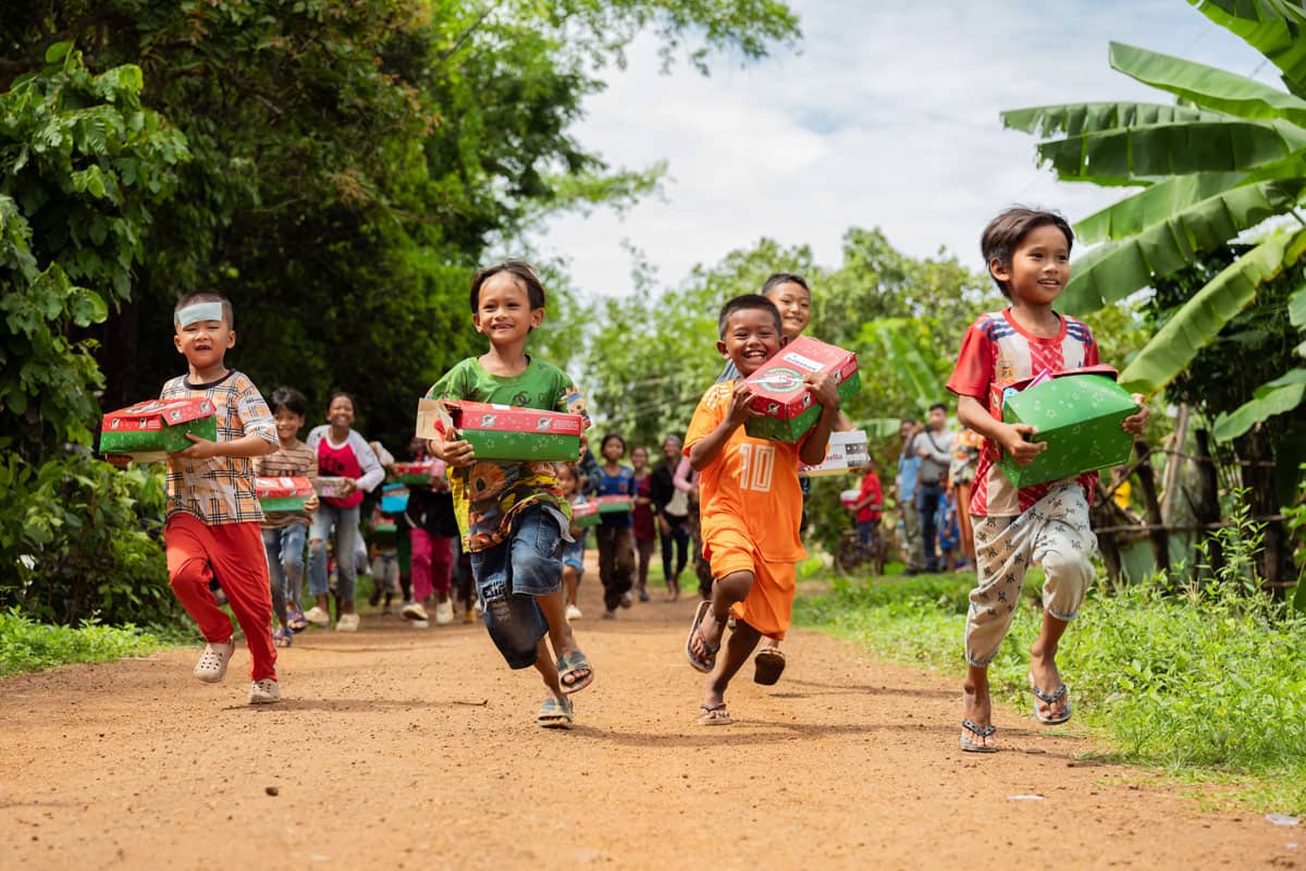 Children running through the jungle with their shoebox gifts.