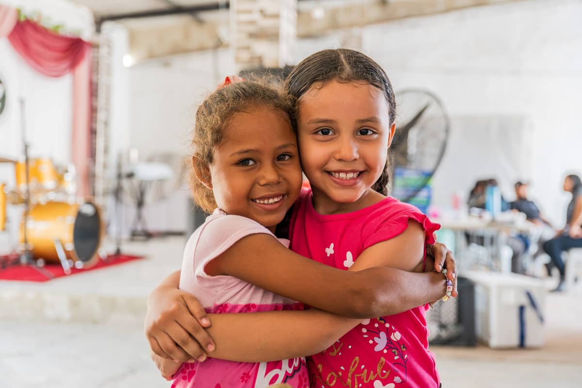Two girls hugging and smiling.