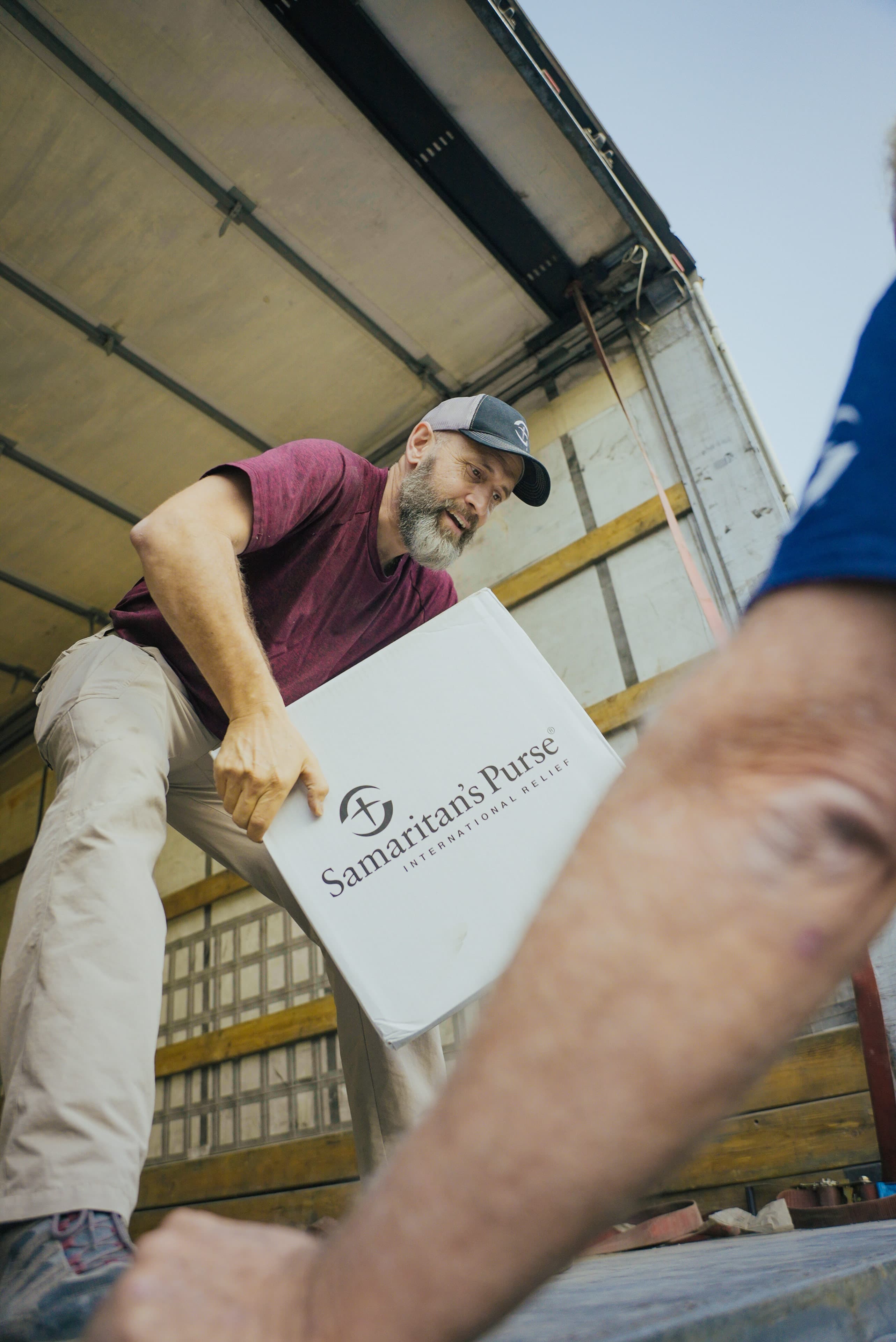 Man unloading truck with Samaritan's Purse International Relief box.