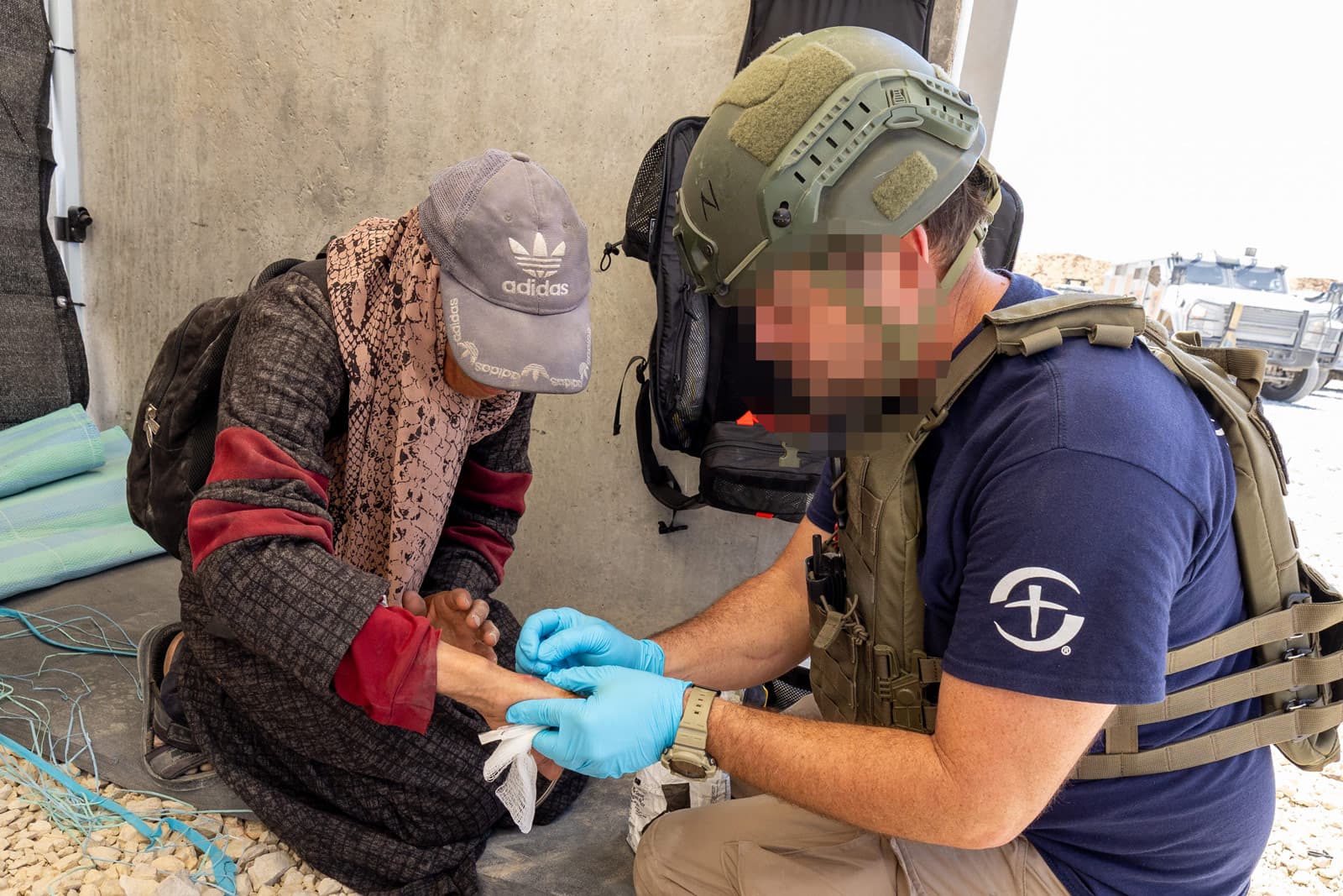 Man loading cart behind donkey with food supplies.