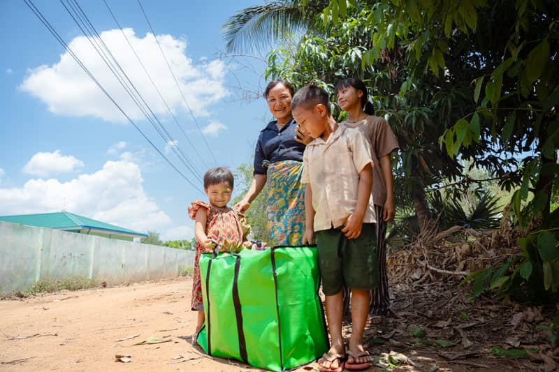 A family smiling with a green gift bag.