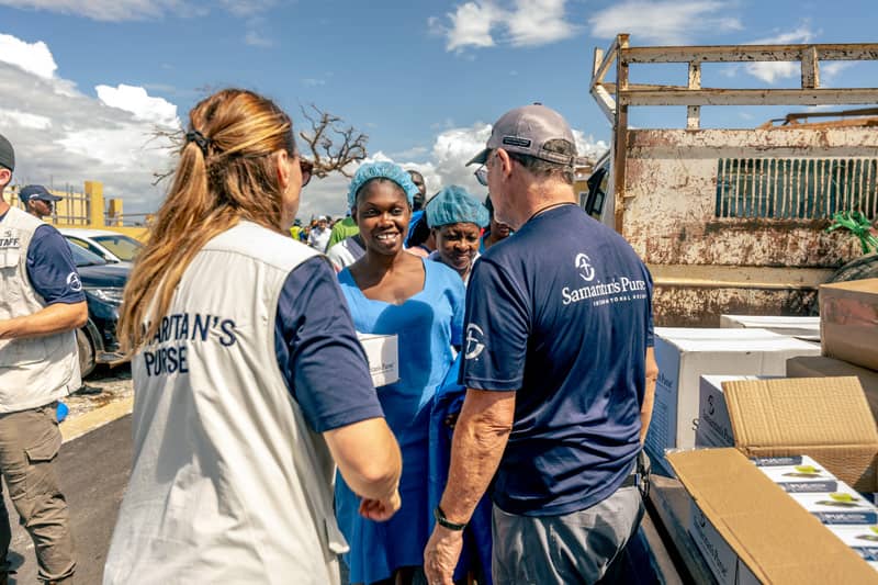 A woman being helped by two Samaritan's Purse staff members.