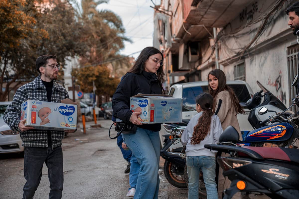 A woman and a man carrying baby supplies.