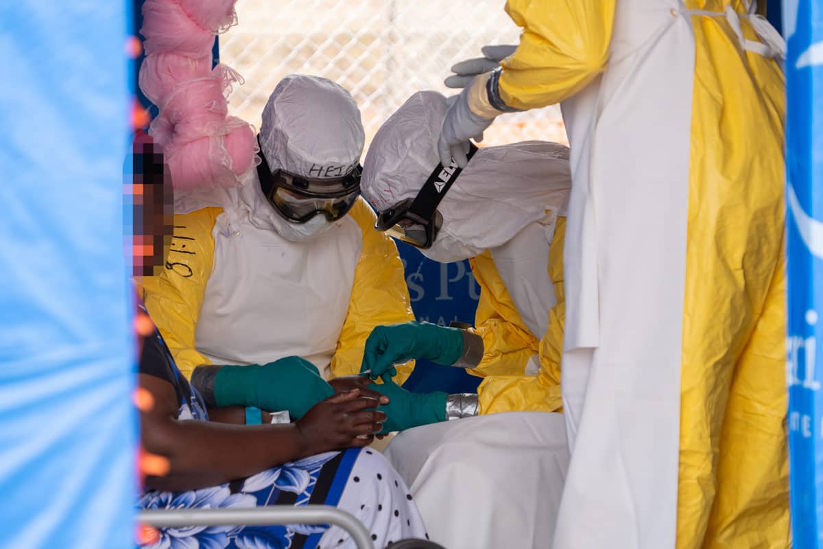 Samaritan's Purse and local medical personnel donned in yellow Personal Protective Equipment are covered head to toe, which includes tightly fitting goggles and sleeves that are duct taped to close the area between gloves and arm coverage. These are part of the protocol to protect workers as they begin to treat a patient who is showing symptoms of Ebola.