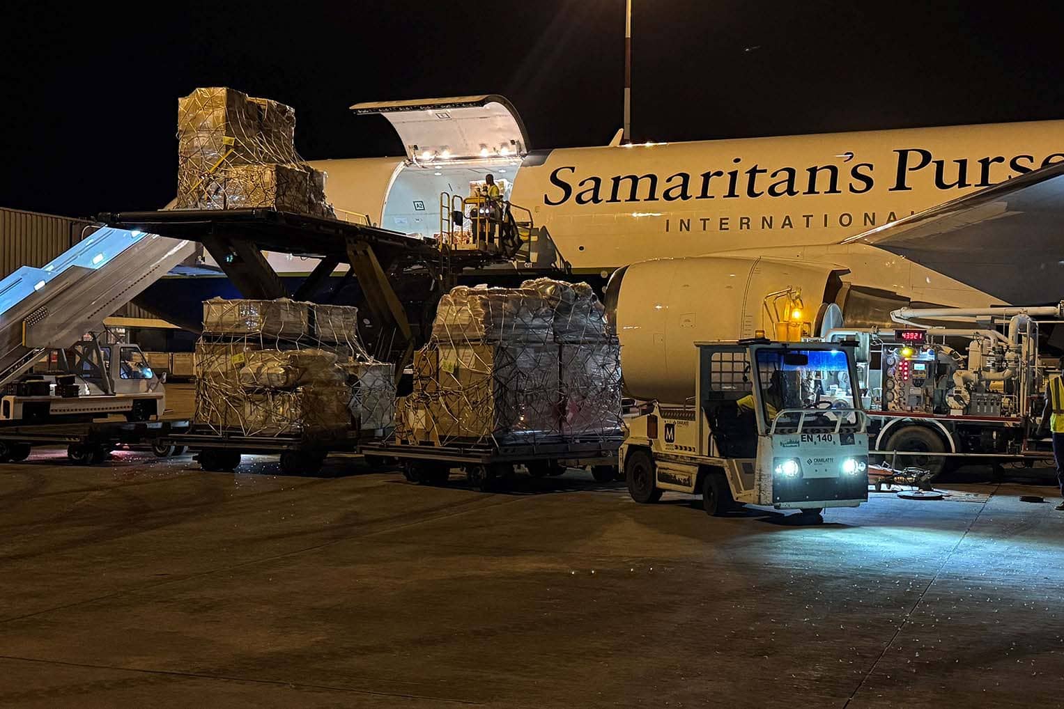 Workers loading emergency supplies into airplane.