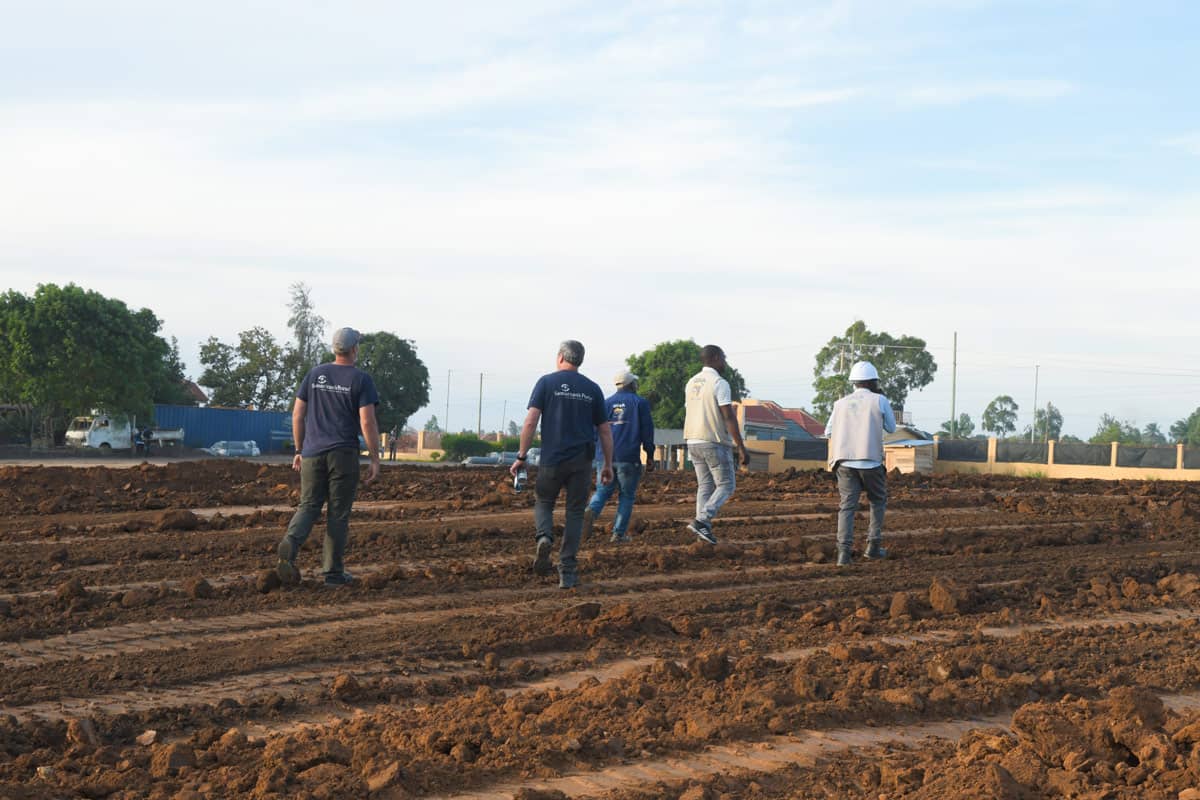 A Group of men walking in a dirt feild.