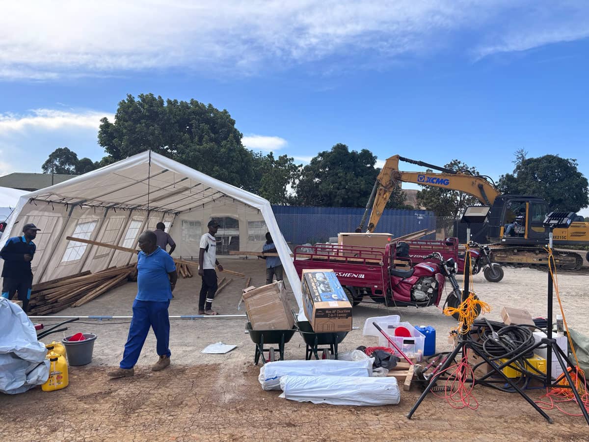 A group of people setting up a tent and medical supplies.