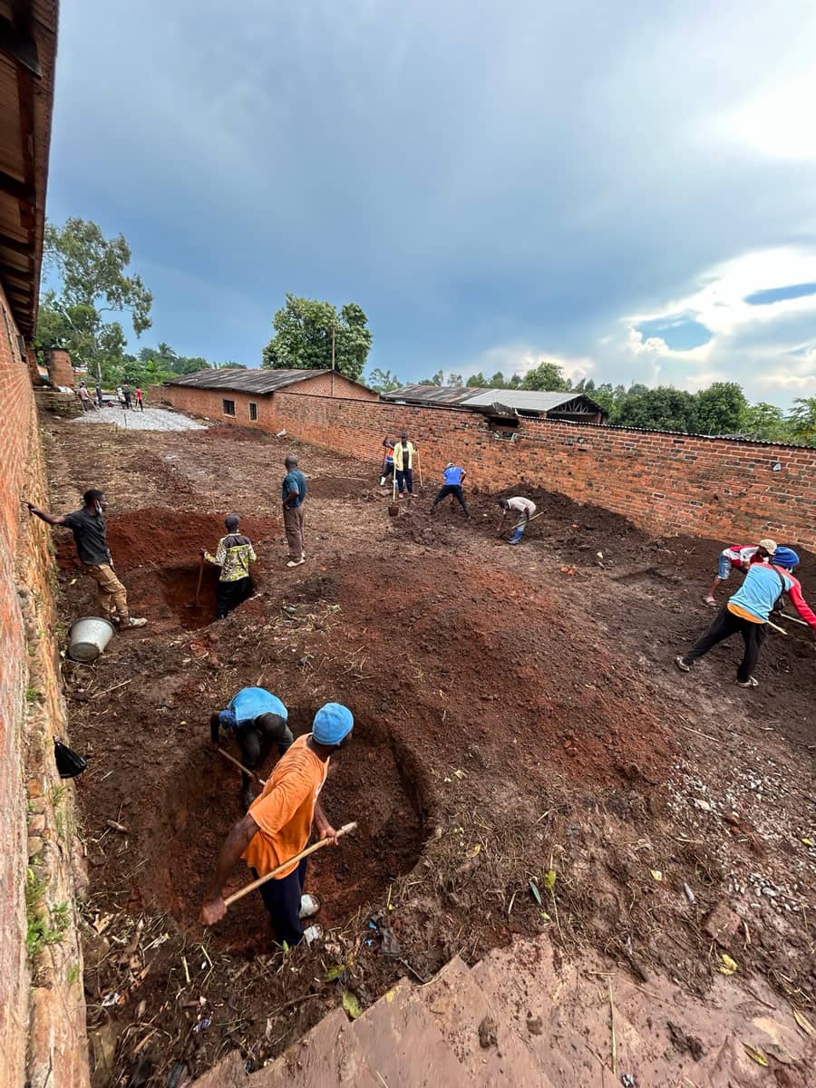 A group of people digging multiple holes in dirt.
