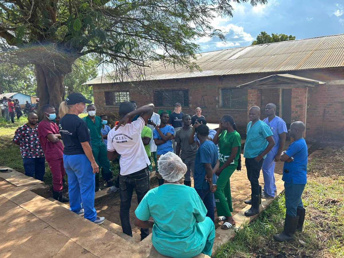 A large group of medical workers standing in a driveway.
