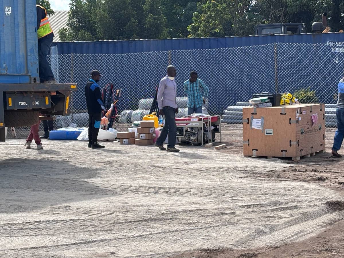 A group of people unloading emergency equipment and supplies off of a truck.c