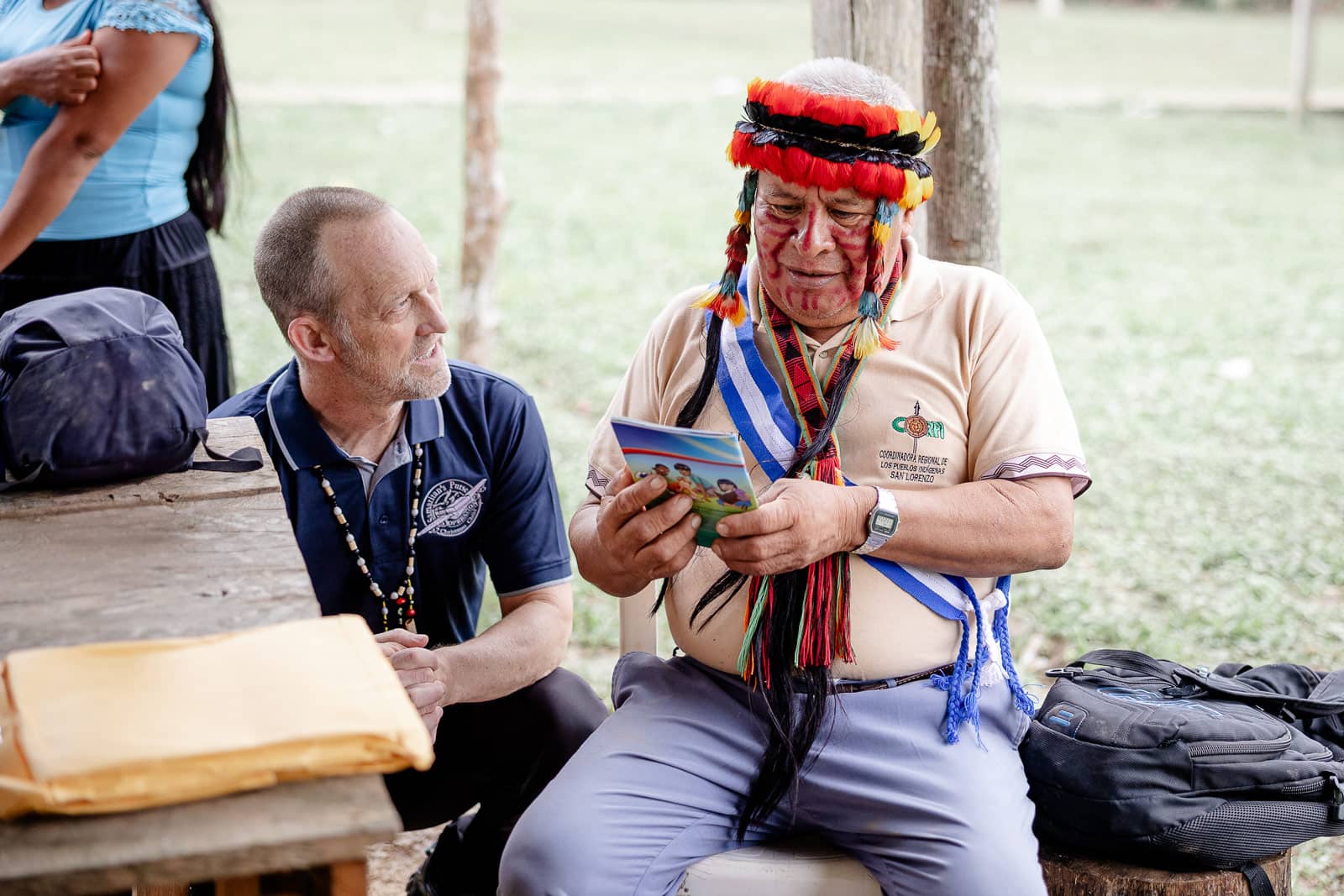 A group of people waving at the enterence to their community.