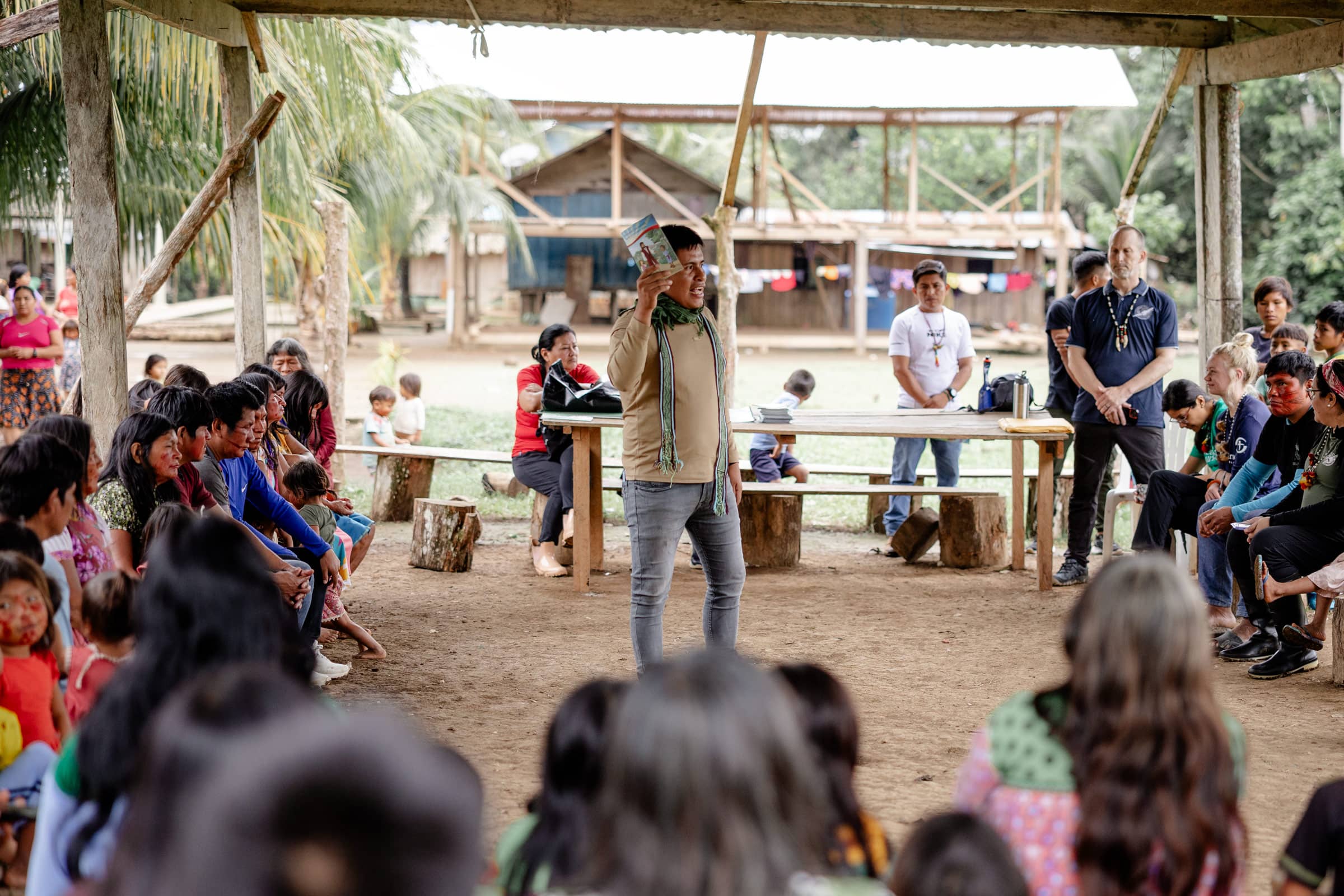 A group of people waving at the enterence to their community.