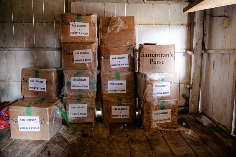 Multiple large tan boxes stacked inside a shed.