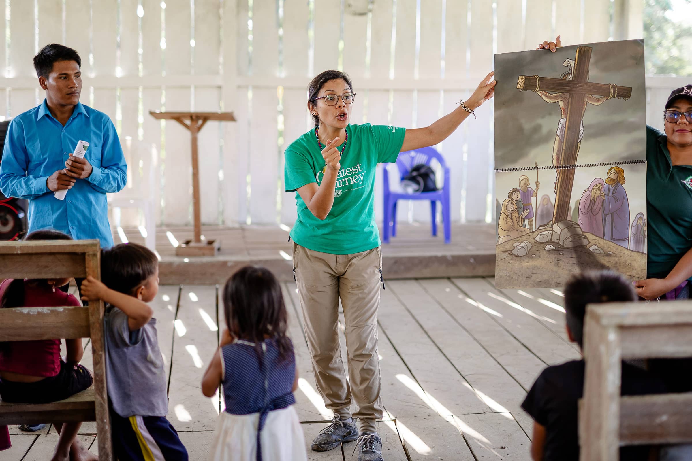 A woman presenting the Gospel to a group of children with pictures.