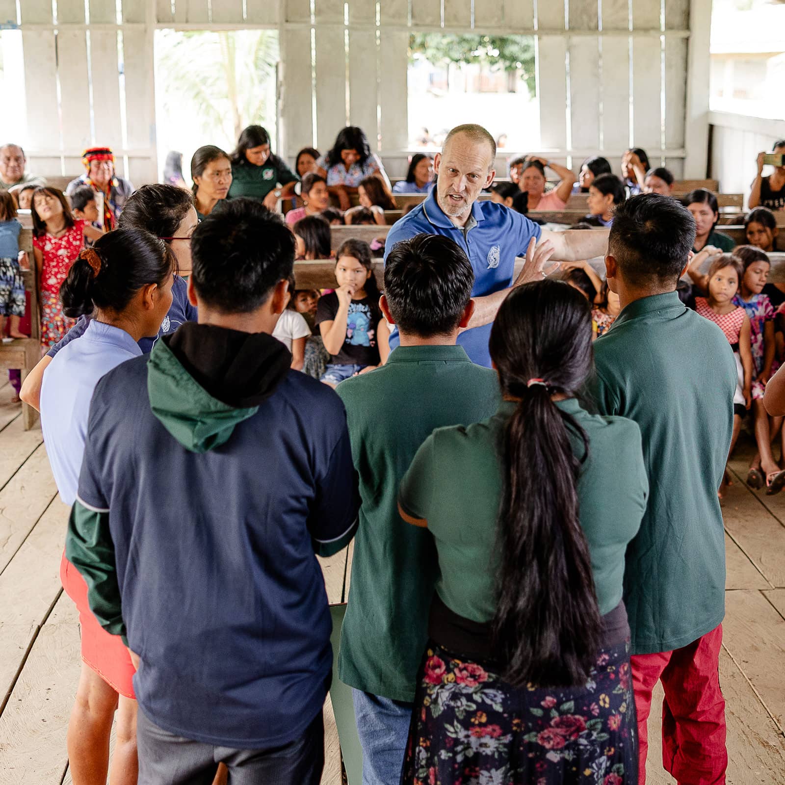 A man training a small group of leaders how to present the Gospel to their community.