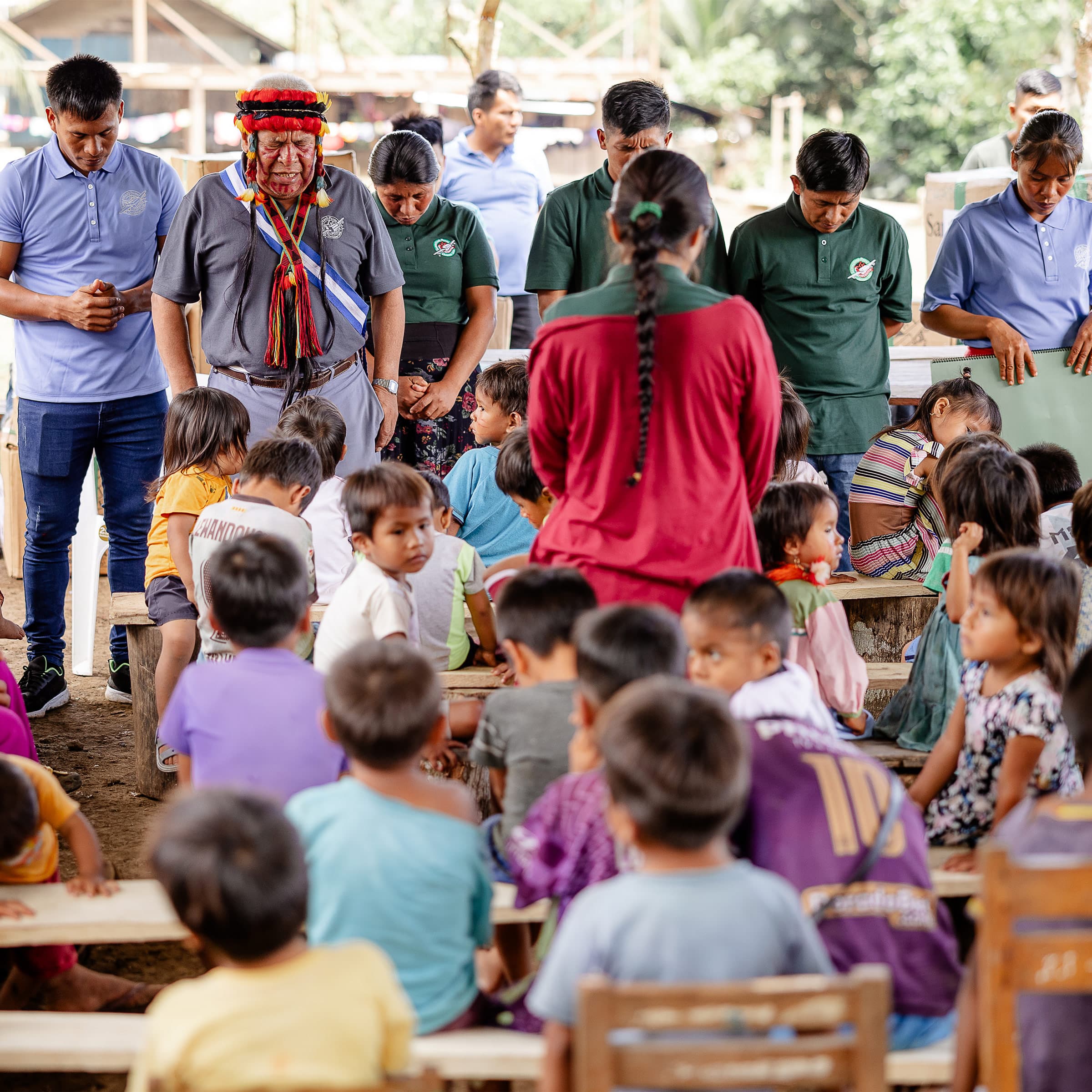 A group of men and women bowing their heads and praying for their community.