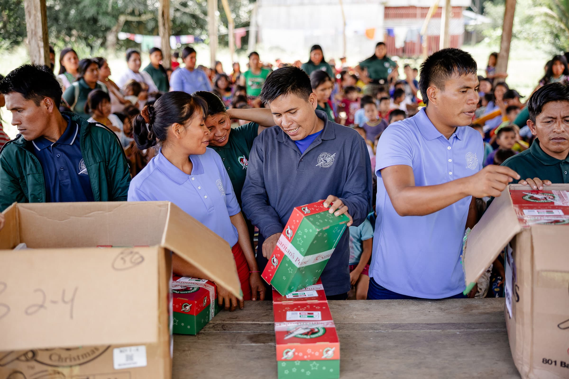 A group of people waving at the enterence to their community.