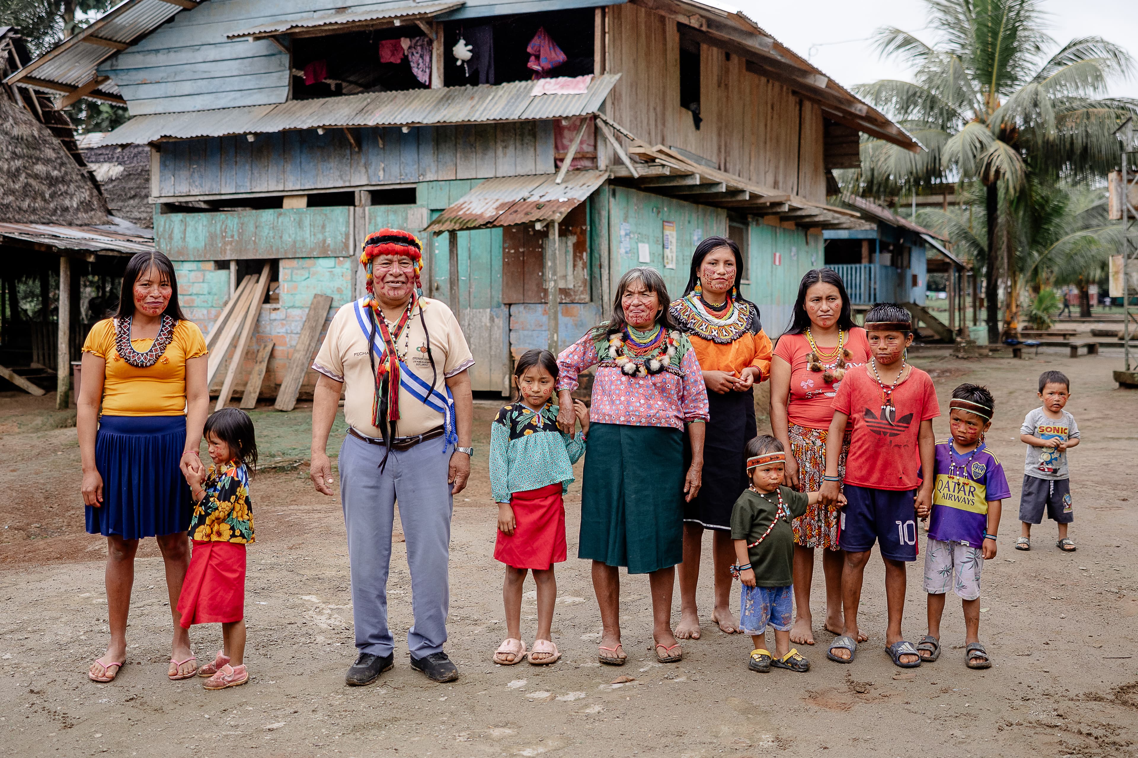 A group of people waving at the enterence to their community.
