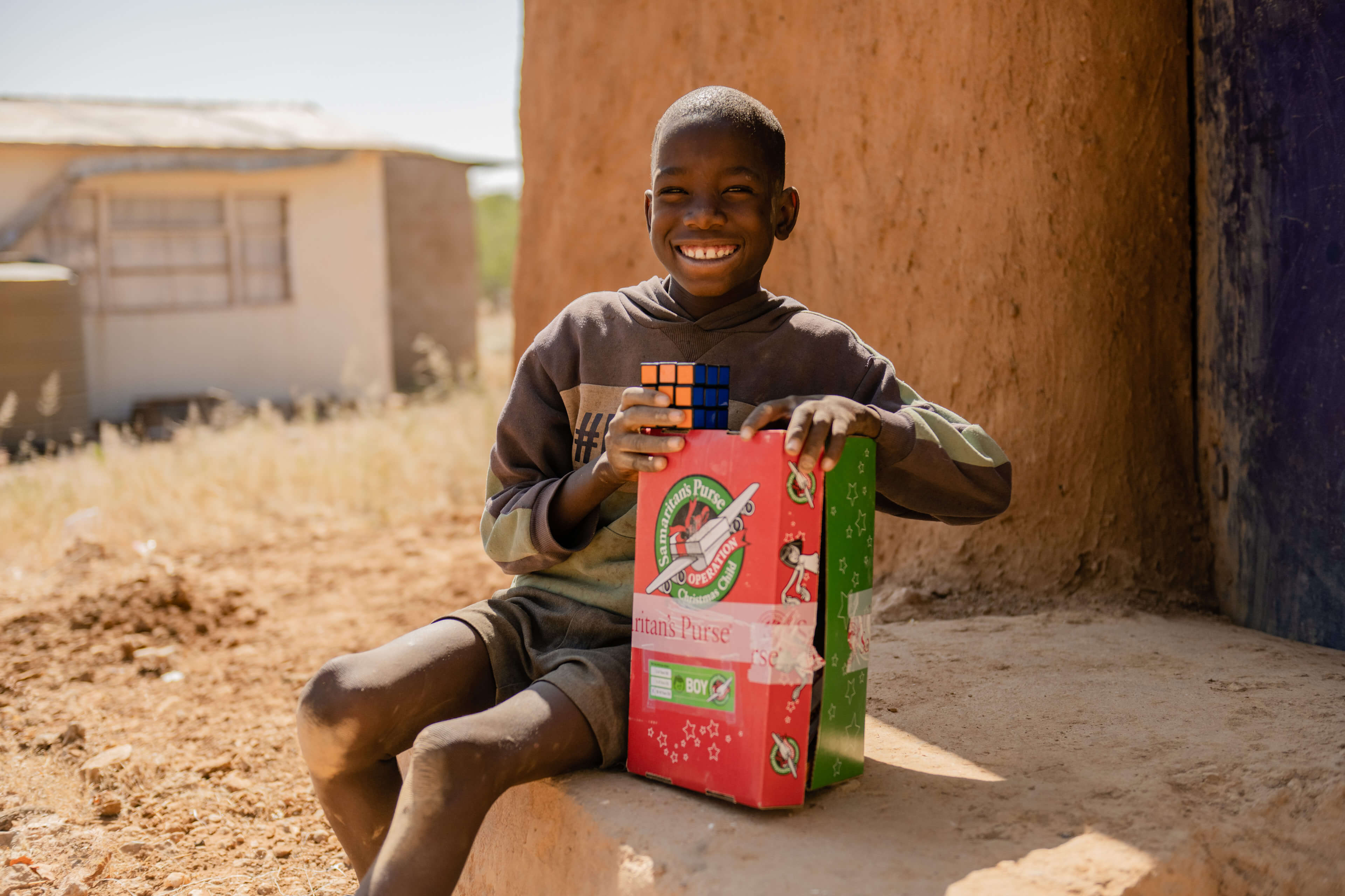 Boy smiling with Operation Christmas Child shoebox.