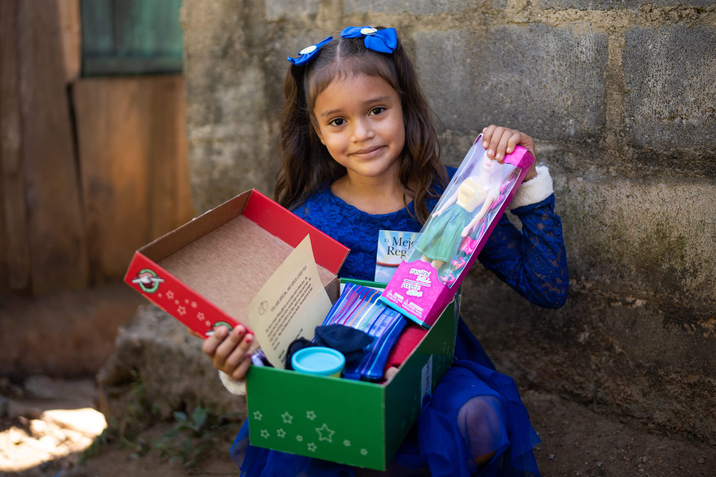 Little girl holding Operation Christmas Child shoebox.