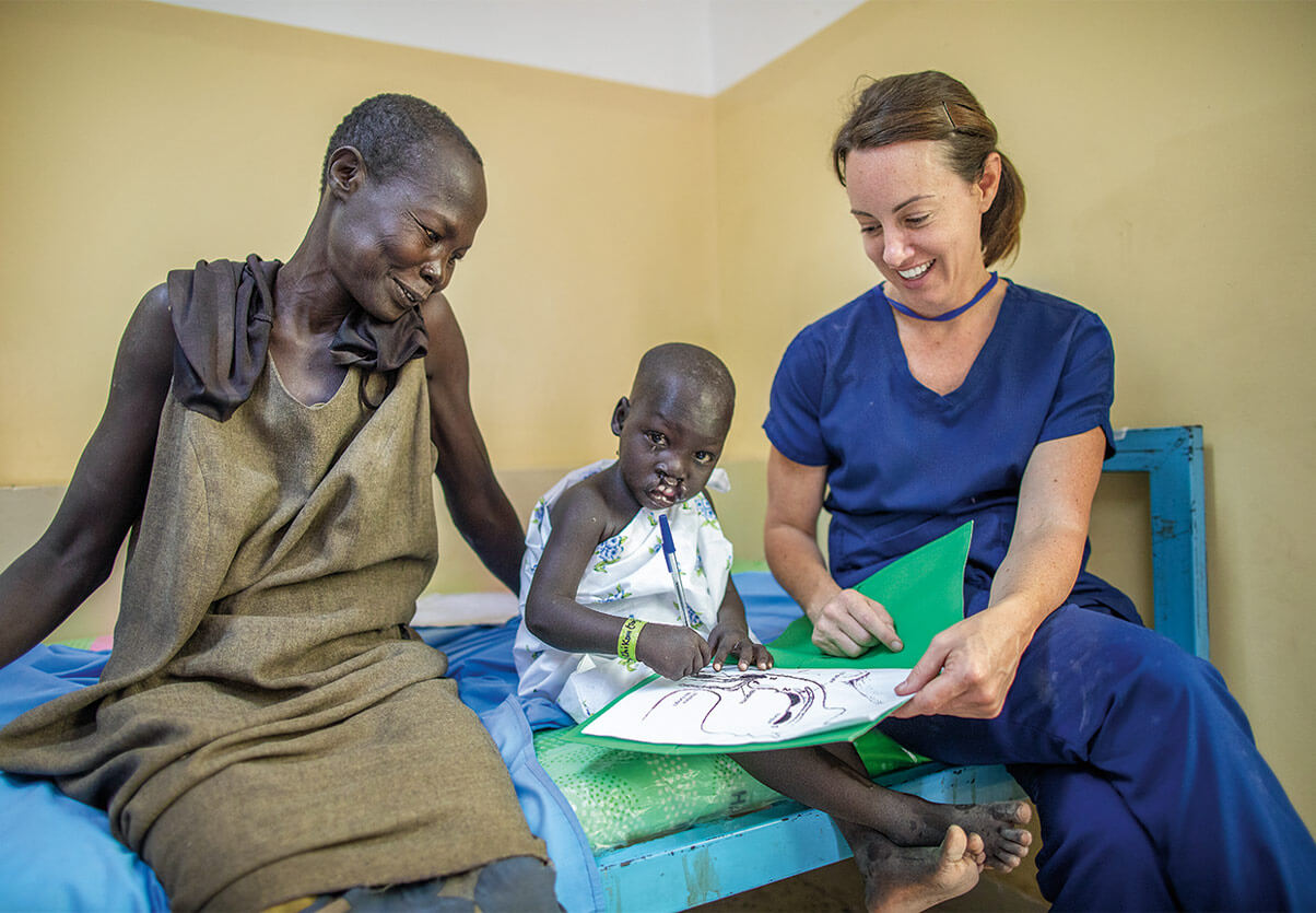 Nurse smiling with mom and child.