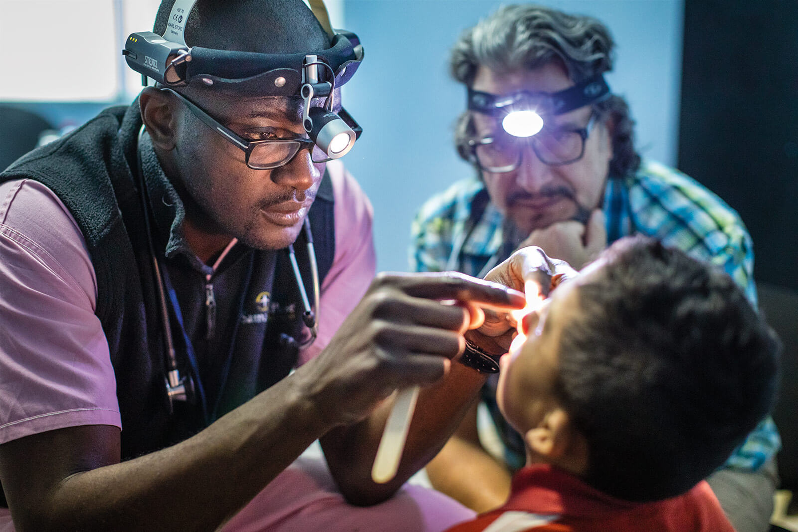 Surgeon giving facial surgery to little boy.