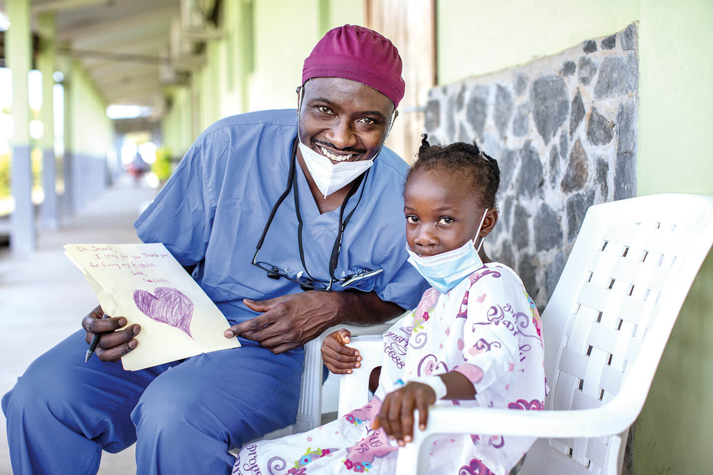 Surgeon smiling with little girl.