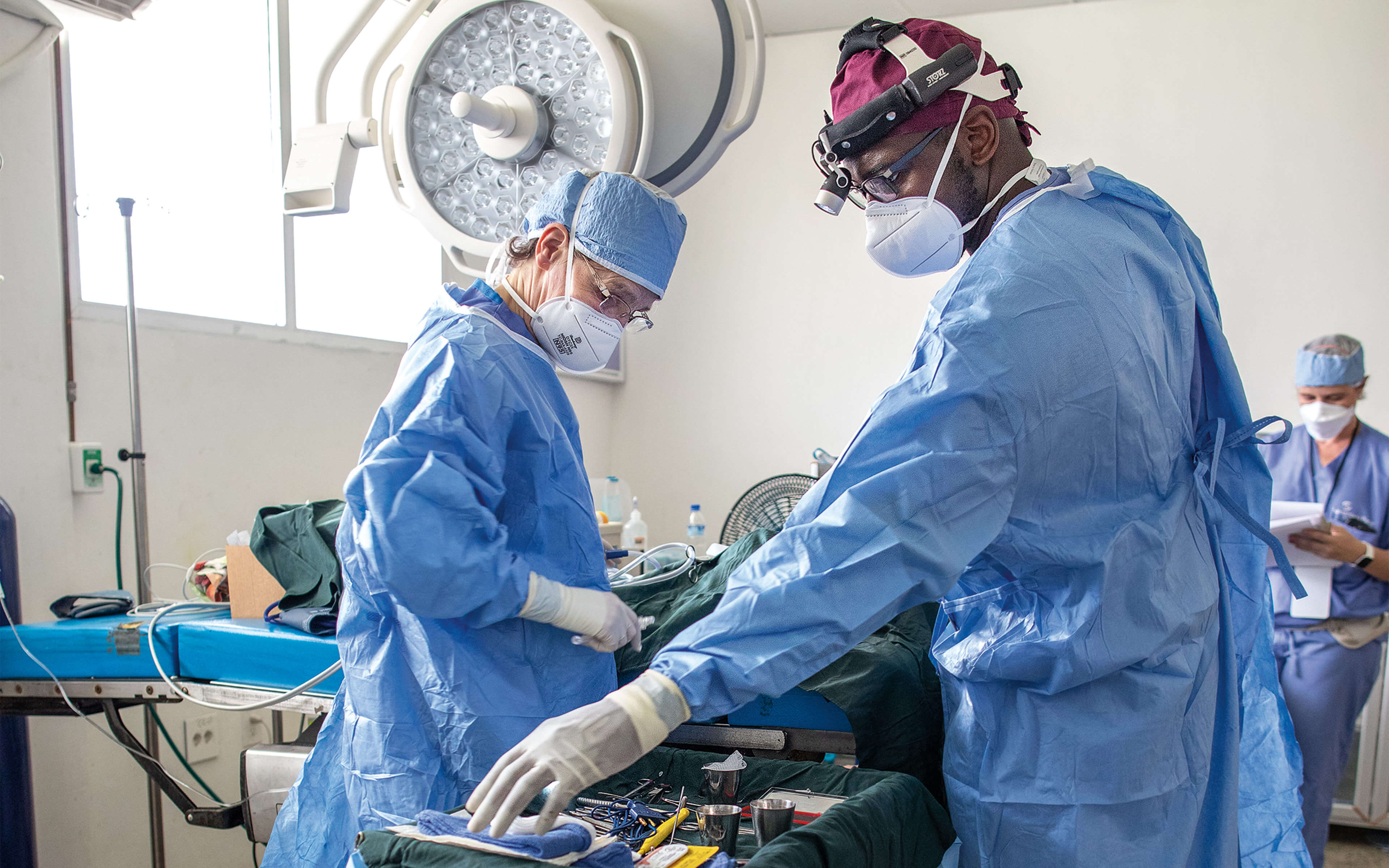 Two surgeons operating on patient.